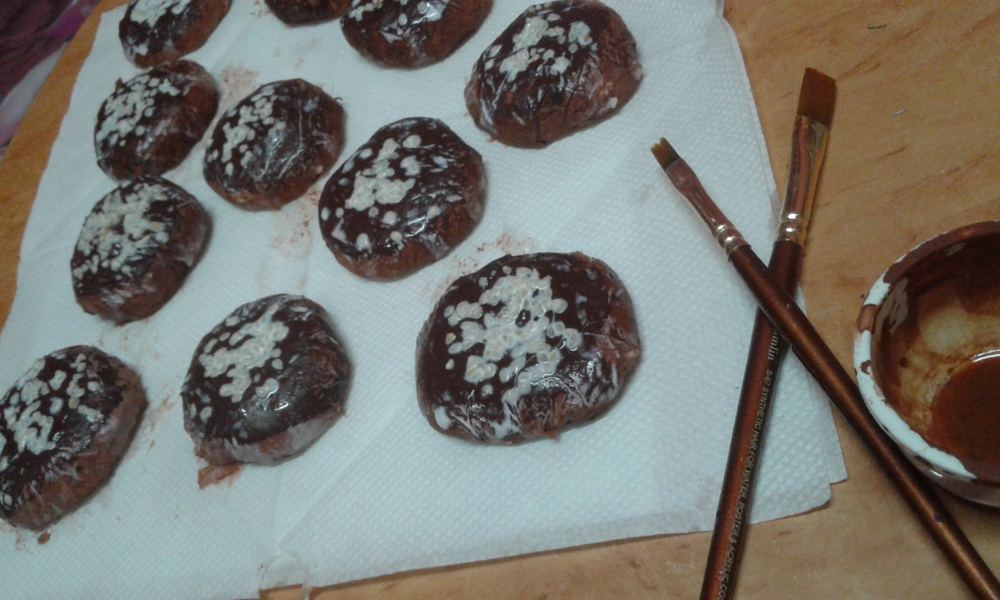 Hand-painted brown and white stones drying on paper towel