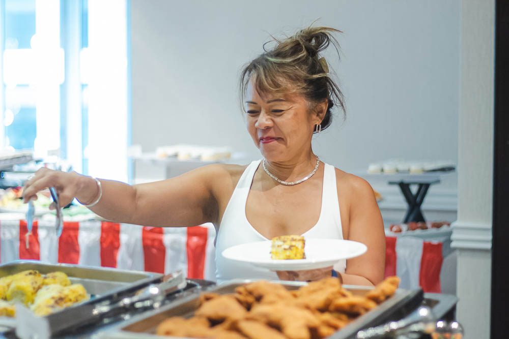 A woman serving herself from a buffet
