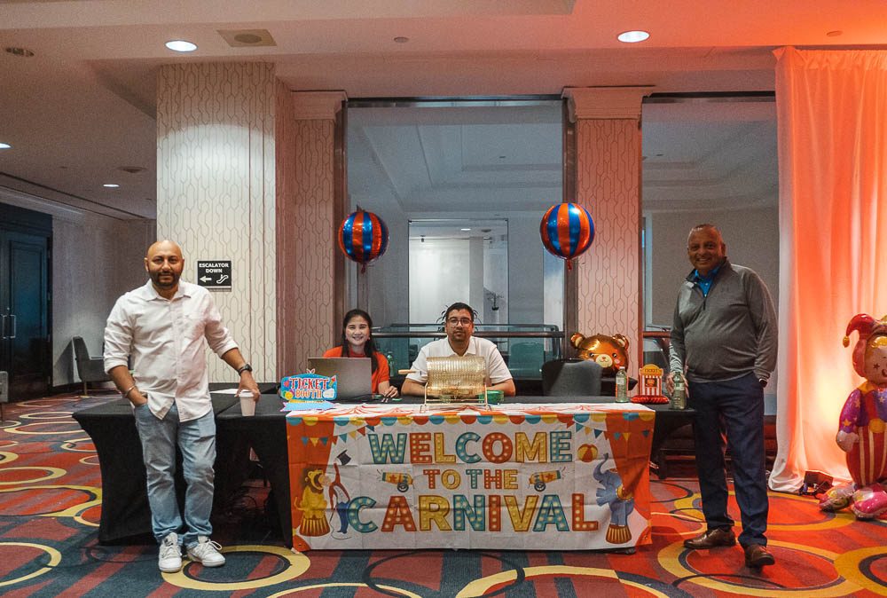 Welcome table with a carnival sign and team members