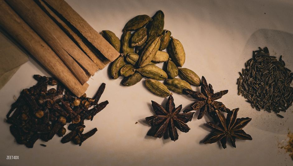 Cinnamon, cardamom and star anise on a dark surface